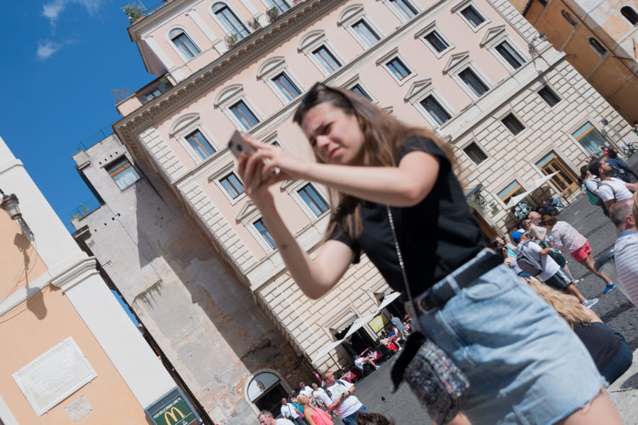 tourist taking a photo in Rome Italy with her phone